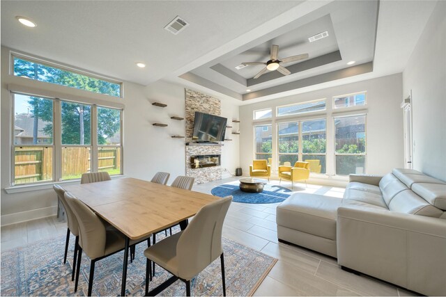 17107 Nulakeast Ct, Houston, TX 77044 - dining room with plenty of natural light, a tray ceiling, a ceiling fan, and a fireplace
