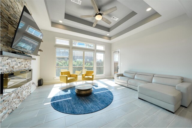 17107 Nulakeast Ct, Houston, TX 77044 - living room featuring ceiling fan, a high ceiling, baseboards, a tray ceiling, and tile patterned flooring