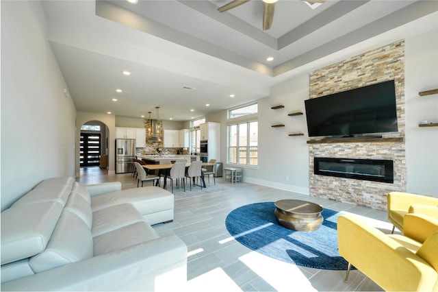 17107 Nulakeast Ct, Houston, TX 77044 - living area featuring recessed lighting, a ceiling fan, arched walkways, a stone fireplace, and light tile patterned floors