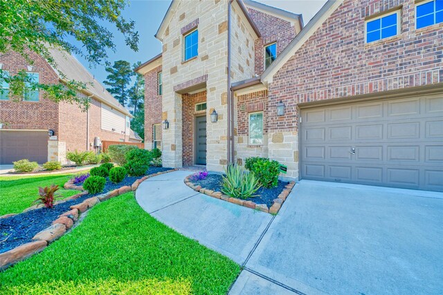 17107 Nulakeast Ct, Houston, TX 77044 - view of exterior entry with a garage, concrete driveway, stone siding, and brick siding