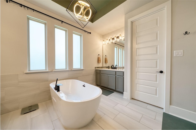 17107 Nulakeast Ct, Houston, TX 77044 - full bathroom featuring a freestanding bath, vanity, a chandelier, tile walls, and wainscoting