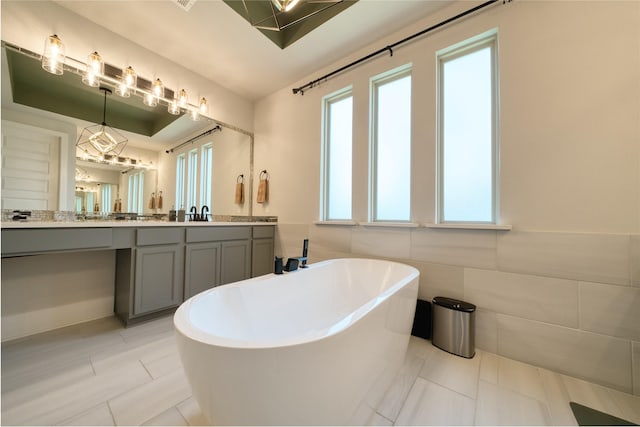 17107 Nulakeast Ct, Houston, TX 77044 - bathroom with a freestanding bath, vanity, tile patterned floors, and tile walls
