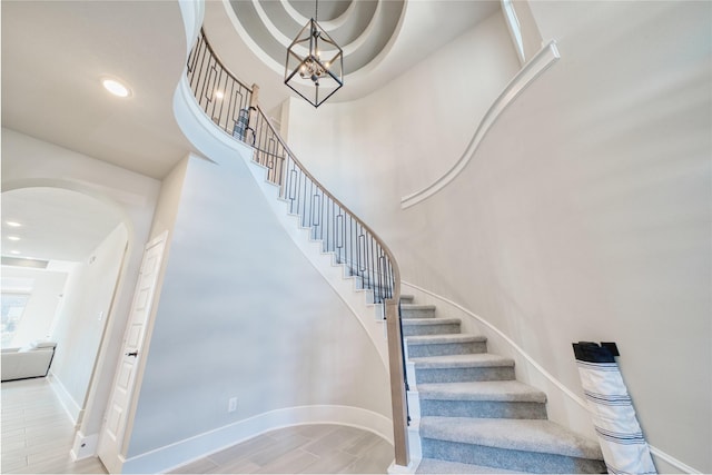 17107 Nulakeast Ct, Houston, TX 77044 - staircase with arched walkways, a chandelier, baseboards, wood finished floors, and recessed lighting