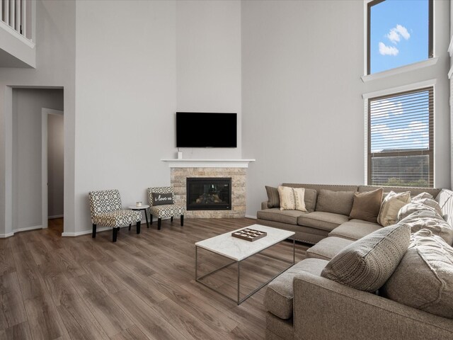 9715 Migrant Hawker Ct, Conroe, TX 77385 - living room with a high ceiling, wood finished floors, a glass covered fireplace, and baseboards