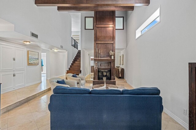 36 Lakeview Dr, Galveston, TX 77551 - living room with a high ceiling, stairway, light tile patterned floors, beam ceiling, and baseboards