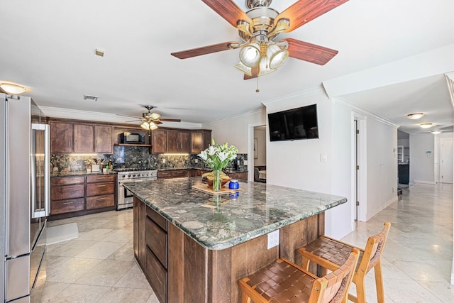 36 Lakeview Dr, Galveston, TX 77551 - kitchen featuring stainless steel appliances, a ceiling fan, ornamental molding, tasteful backsplash, and a center island