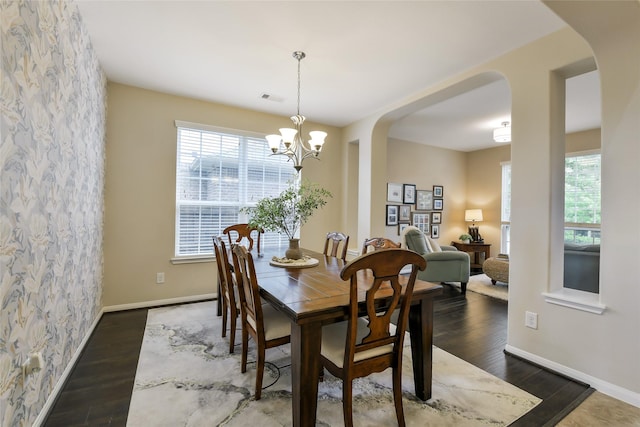 19538 Salt Grass Meadow Dr, Cypress, TX 77433 - dining space featuring arched walkways, a chandelier, wood finished floors, and baseboards