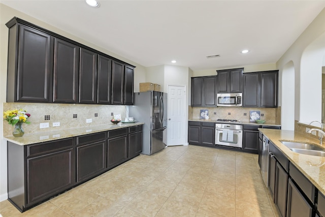 19538 Salt Grass Meadow Dr, Cypress, TX 77433 - kitchen featuring stainless steel appliances, a sink, light stone countertops, backsplash, and light tile patterned flooring