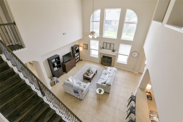 19538 Salt Grass Meadow Dr, Cypress, TX 77433 - living area with a high ceiling, stairway, a ceiling fan, a tiled fireplace, and light tile patterned floors