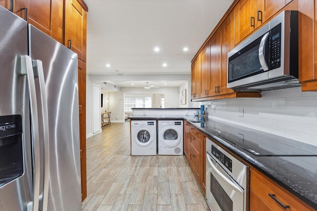 811 Lovett Blvd Unit 26, Houston, TX 77006 - kitchen featuring appliances with stainless steel finishes, brown cabinets, washing machine and dryer, tasteful backsplash, and dark stone counters