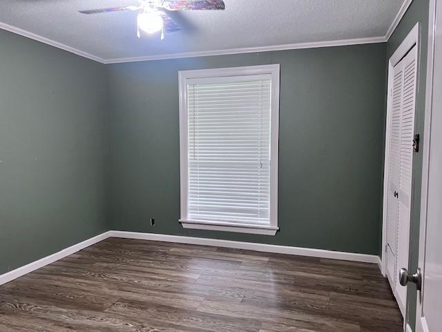8594 Morgan Ln, Orange, TX 77632 - unfurnished room with ceiling fan, dark wood-type flooring, crown molding, baseboards, and a textured ceiling