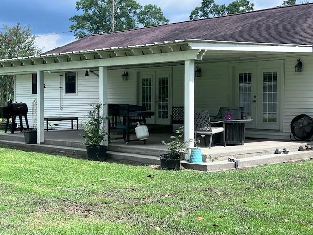 8594 Morgan Ln, Orange, TX 77632 - rear view of house featuring french doors, a lawn, and a patio area