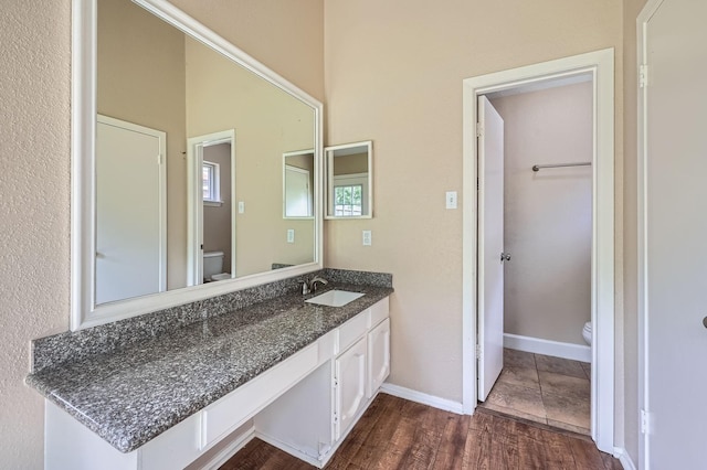 9519 Landry Blvd, Spring, TX 77379 - bathroom with toilet, vanity, wood finished floors, and baseboards