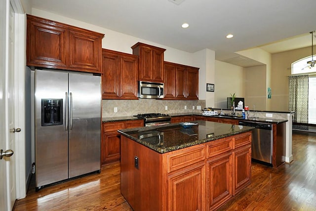 2366 Bastrop St, Houston, TX 77004 - kitchen featuring stainless steel appliances, a peninsula, dark wood-style floors, a kitchen island, and tasteful backsplash