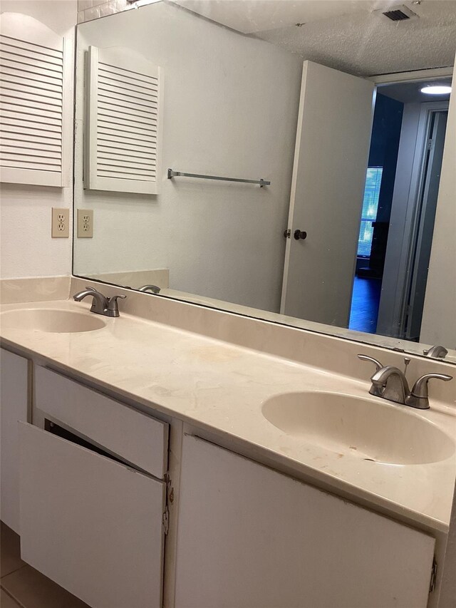 10049 Westpark Dr Unit 120, Houston, TX 77042 - full bath with double vanity and a textured ceiling