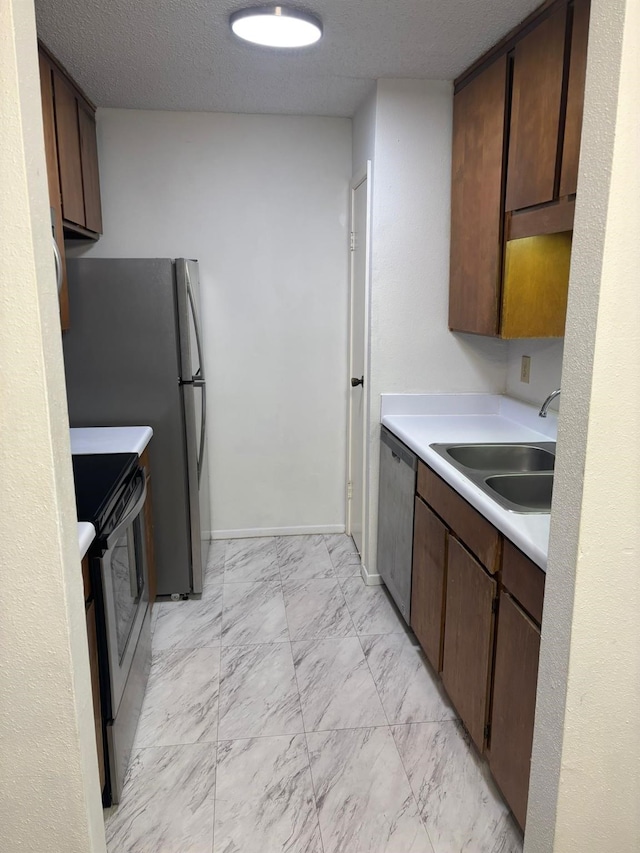 10049 Westpark Dr Unit 120, Houston, TX 77042 - kitchen with appliances with stainless steel finishes, a sink, light countertops, light marble finish floors, and dark brown cabinetry