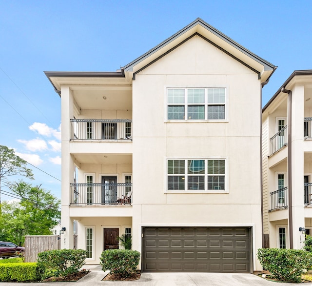 1221 W 25th St Unit D, Houston, TX 77008 - townhome / multi-family property with an attached garage, stucco siding, concrete driveway, and a balcony