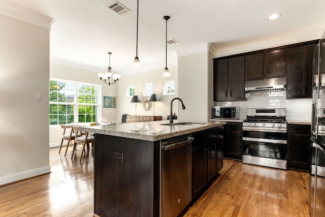 1221 W 25th St Unit D, Houston, TX 77008 - kitchen with stainless steel appliances, under cabinet range hood, a sink, crown molding, and a chandelier