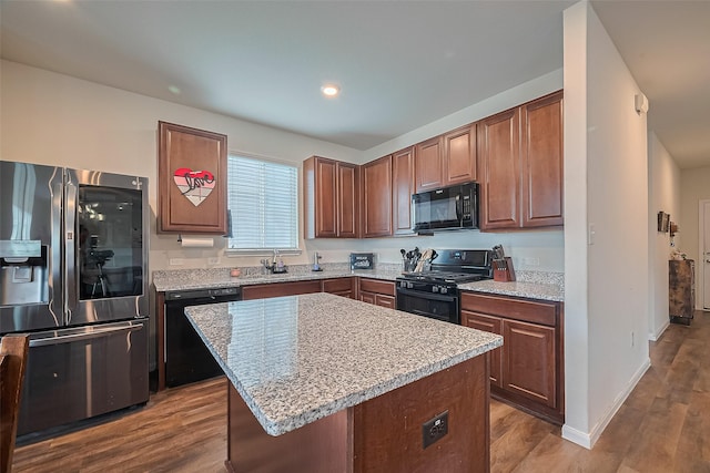 23834 Thistle Spud Ln, Hockley, TX 77447 - kitchen with black appliances, wood finished floors, a sink, a center island, and baseboards