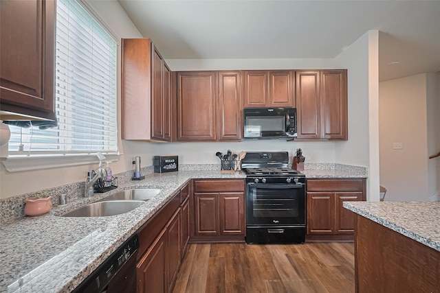 23834 Thistle Spud Ln, Hockley, TX 77447 - kitchen with black appliances, dark wood-style flooring, a sink, and light stone counters