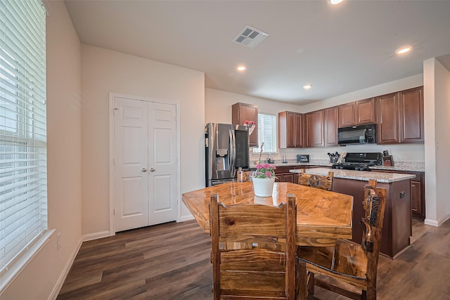 23834 Thistle Spud Ln, Hockley, TX 77447 - kitchen with stainless steel fridge with ice dispenser, black microwave, stove, dark wood finished floors, and recessed lighting