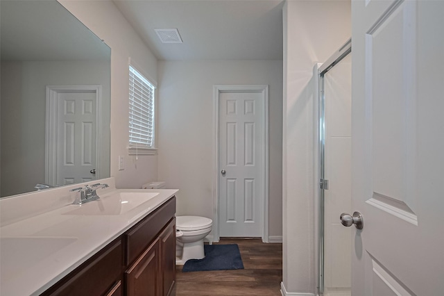 23834 Thistle Spud Ln, Hockley, TX 77447 - bathroom featuring wood finished floors, double vanity, a shower stall, toilet, and baseboards