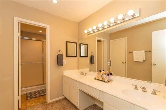 1620 Wellington Pl Unit 303, Beaumont, TX 77706 - full bathroom featuring double vanity, a shower with shower door, and baseboards