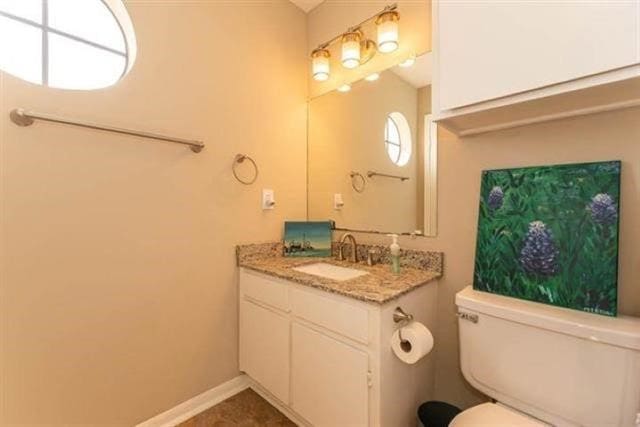 1620 Wellington Pl Unit 303, Beaumont, TX 77706 - half bathroom featuring vanity, toilet, and baseboards