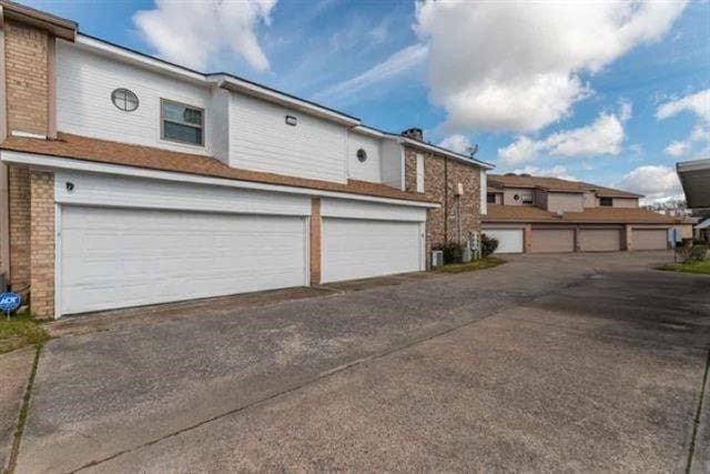 1620 Wellington Pl Unit 303, Beaumont, TX 77706 - view of front of house with concrete driveway, a garage, and brick siding