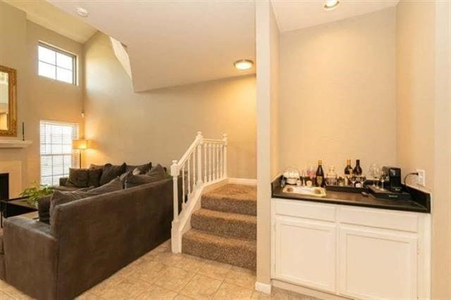 1620 Wellington Pl Unit 303, Beaumont, TX 77706 - indoor wet bar featuring plenty of natural light, stairs, a fireplace, and light tile patterned floors