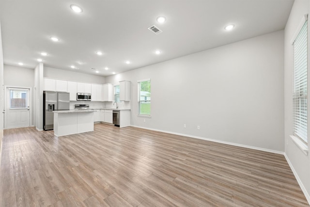 705 Little River Dr, Montgomery, TX 77316 - unfurnished living room with recessed lighting, plenty of natural light, light wood-style flooring, and baseboards