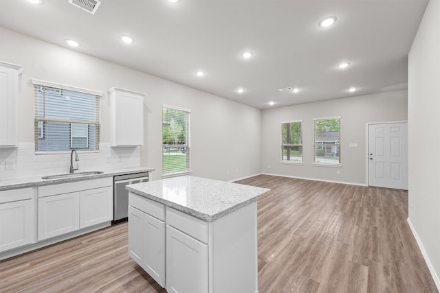 705 Little River Dr, Montgomery, TX 77316 - kitchen featuring a sink, dishwasher, light wood-style floors, tasteful backsplash, and white cabinets