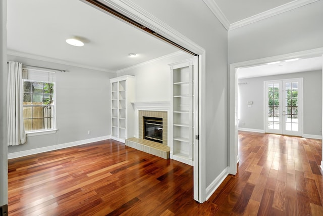 263 S Crimson Clover Ct, The Woodlands, TX 77381 - unfurnished living room featuring hardwood / wood-style flooring, a brick fireplace, french doors, and ornamental molding