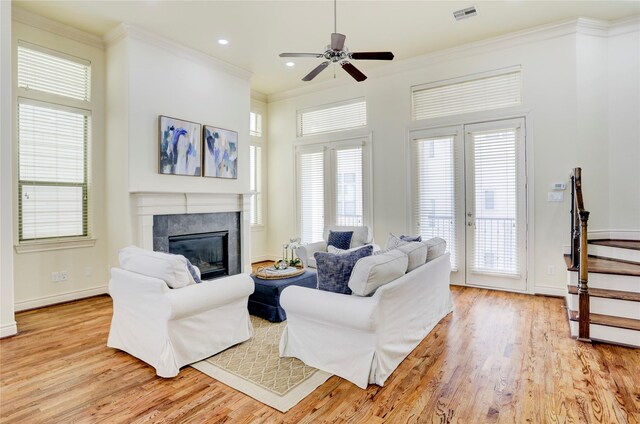9617 Pemberton Crescent Dr, Houston, TX 77025 - living room with light wood-style flooring, ornamental molding, ceiling fan, a tiled fireplace, and baseboards