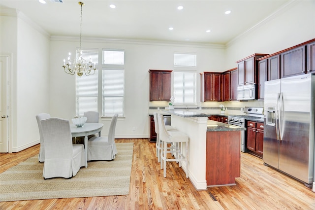 9617 Pemberton Crescent Dr, Houston, TX 77025 - kitchen with appliances with stainless steel finishes, a chandelier, reddish brown cabinets, a center island, and crown molding