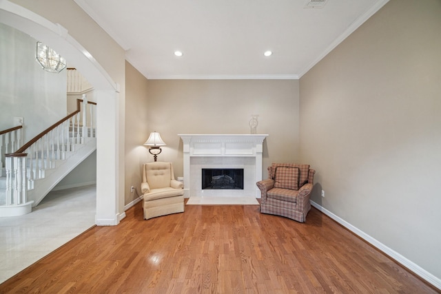 6010 Maple Knob Ct, Kingwood, TX 77345 - sitting room featuring crown molding, wood finished floors, a high end fireplace, stairs, and arched walkways