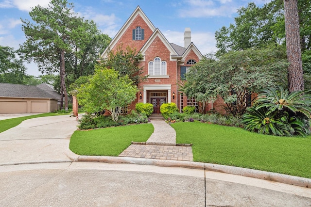 6010 Maple Knob Ct, Kingwood, TX 77345 - colonial inspired home featuring brick siding, a front yard, a chimney, french doors, and driveway