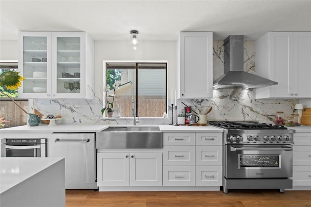 3022 Grove Terrace Dr, Houston, TX 77345 - kitchen with stainless steel appliances, wall chimney exhaust hood, white cabinets, tasteful backsplash, and light countertops
