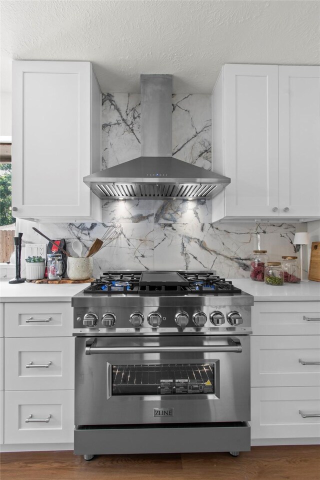 3022 Grove Terrace Dr, Houston, TX 77345 - kitchen with high end stainless steel range, wall chimney range hood, backsplash, white cabinets, and a textured ceiling