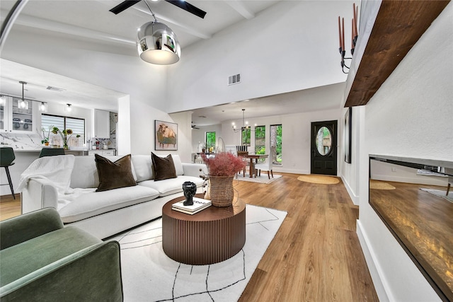 3022 Grove Terrace Dr, Houston, TX 77345 - living area with light wood-style flooring, beamed ceiling, a chandelier, ceiling fan, and baseboards