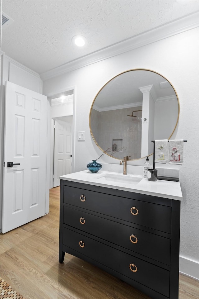3022 Grove Terrace Dr, Houston, TX 77345 - bathroom with wood finished floors, vanity, a textured ceiling, ornamental molding, and baseboards