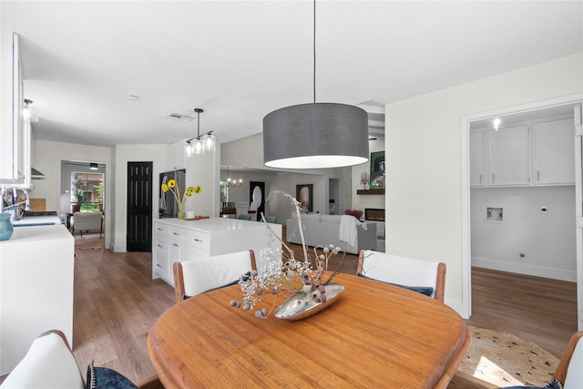 3022 Grove Terrace Dr, Houston, TX 77345 - dining area with light wood-type flooring, a chandelier, and baseboards