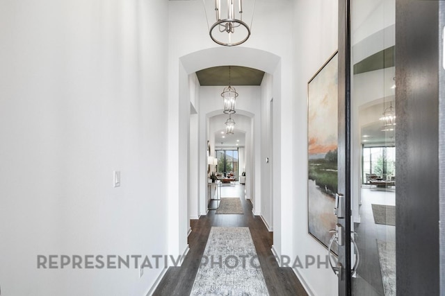 4315 Southpoint Way, Fulshear, TX 77441 - hallway featuring arched walkways, dark wood-style flooring, a chandelier, and a high ceiling
