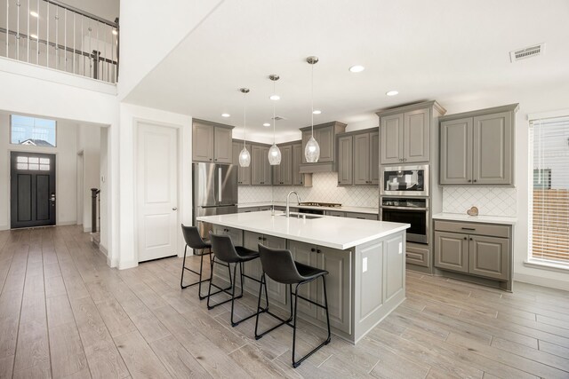 2326 Bristlegrass Dr, Katy, TX 77494 - kitchen featuring gray cabinetry, stainless steel appliances, light wood finished floors, and recessed lighting