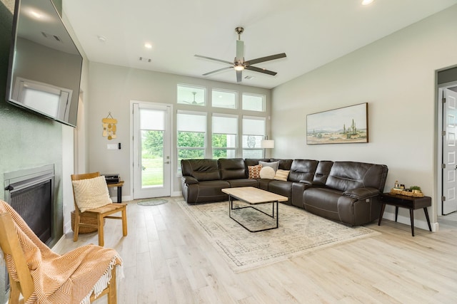 9715 Highland Pointe Dr, Needville, TX 77461 - living room featuring light wood finished floors, a ceiling fan, a glass covered fireplace, recessed lighting, and baseboards
