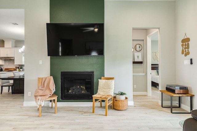 9715 Highland Pointe Dr, Needville, TX 77461 - living area featuring light wood finished floors, a glass covered fireplace, and baseboards