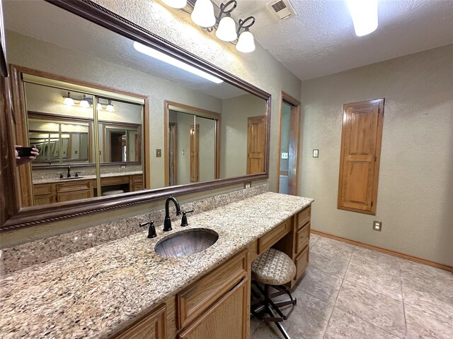 113 Fm 3454th Rd, Huntsville, TX 77320 - bathroom with a textured wall, vanity, baseboards, tile patterned floors, and a textured ceiling