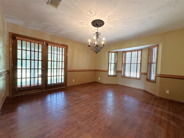 113 Fm 3454th Rd, Huntsville, TX 77320 - spare room featuring a chandelier, wood finished floors, a textured ceiling, and baseboards