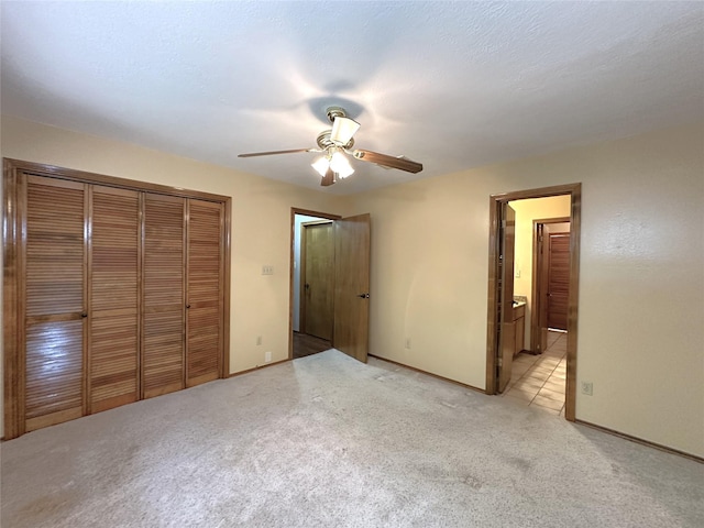 113 Fm 3454th Rd, Huntsville, TX 77320 - unfurnished bedroom with a closet, light carpet, baseboards, a ceiling fan, and ensuite bathroom