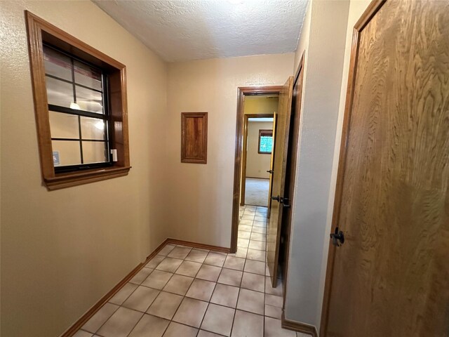 113 Fm 3454th Rd, Huntsville, TX 77320 - hallway featuring a textured ceiling, light tile patterned floors, and baseboards
